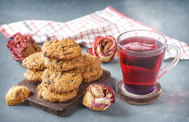 Oatmeal cookies with prunes next to pink tea and roses