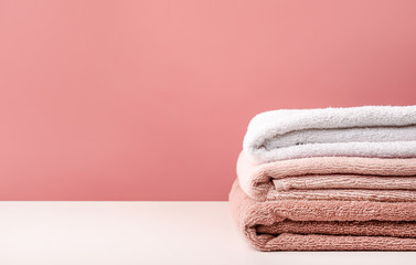 Fototapeta na wymiar Stack of bath towels on pink background