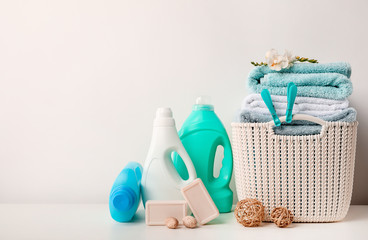 Laundry basket with towels and freesia flower, detergents, soap and bamboo balls on white background