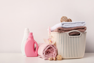 Laundry basket with towels, detergents, bamboo balls and white orchid flower on white background