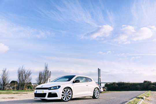parked white hatchback against the background of the bridge and