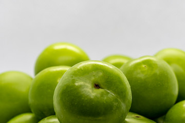 Fototapeta na wymiar close up green fresh plums or greengage in a bowl ,fruit wallpaper. front view
