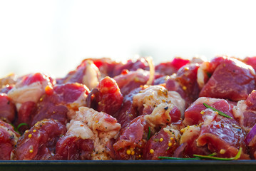 Prepared marinated with onions and herbs pieces of meat for barbecue. raw marinated skewers on skewers. Marinated beef BBQ Skewers arranged with pepper ready for grill.
