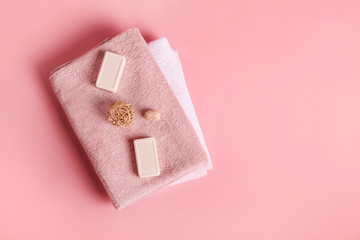 Bath towels, soap and bamboo balls on pink background