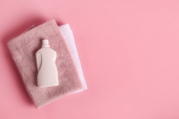 Bath towels and detergent on pink background
