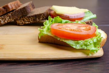 sandwiches cutting board on a dark background