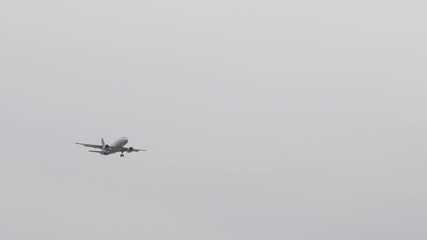 The Commercial passenger airplane flying overhead on sunny day