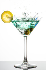 cocktail with martini, olives and lime wedge