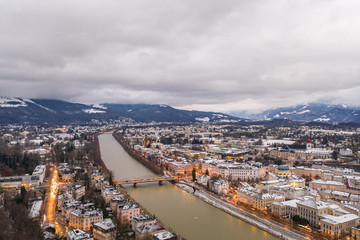 Aerial drone overview of eastside of Salzburg old town along Salzach river in Austria in winter