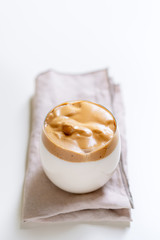 Korean Coffee Dalgona. Iced fluffy creamy whipped trend coffee drink with coffee foam and milk. Covid-19 city lock down and self quarantine trendy IT-drink durink, stay at home concept.
