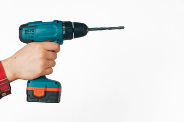 male hands hold a drill on a light background. The concept of building tools for furniture assembly