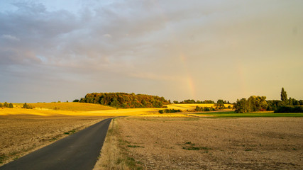 abgeerntete Felder in trockener Sommerlandschaft - leichter Regenbogen