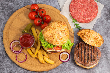 Tasty grilled home made burgers with beef, tomato, cheese, cucumber and lettuce. Top view. Flat lay