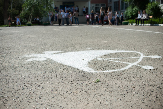 The school bell is drawn in chalk on the asphalt-it is a symbol of the beginning of the school year or the end of school. Concept of education. Back to school.