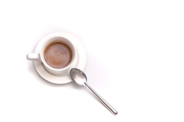 A cup of hot coffee  with a silver tea spoon top view on white isolated background with copy space 