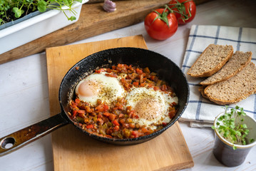 person eats Izrael scrambled eggs shakshuka with whole grain dark bread