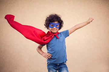 A portrait of kid boy in costume of superhero. Childhood and success concept