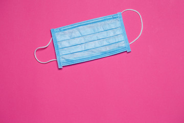 Blue medical surgical mask for protection against the virus on a colored background