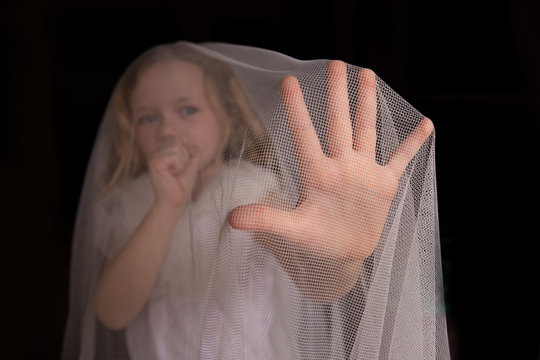 Ni&ntilde;a, mujer joven cubierta por tela m&eacute;dica protectora mirando a la c&aacute;mara , tosiendo y ense&ntilde;ando la mano para protegerse y parar el virus, concepto de coronavirus .