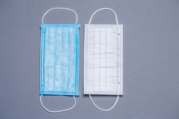 Blue and white medical surgical mask for protection against the virus on a colored background