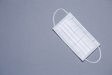 White medical surgical mask for protection against the virus on a colored background