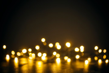 Obraz na płótnie Canvas Lights in bokeh background. Yellow and gold lights in bokeh on a black dark background. Holiday, background decoration concept.