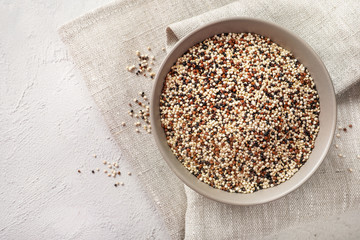 Mixed quinoa seeds in ceramic bowl on white backround.