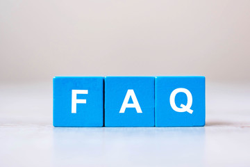 wooden cube blocks with FAQ text ( frequently asked questions) on table background. Financial,...
