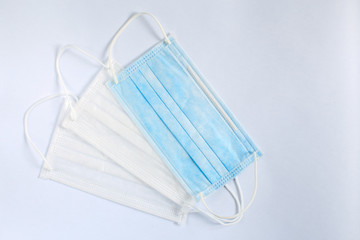 Medical supplies on a white background top view, medical face masks in white and blue