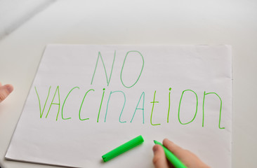 
Child's drawing on which is written in colored letters "no vaccination"
