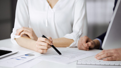Unknown businessman and woman discussing contract in office. closeup.Business people or lawyers working together at meeting. Teamwork and partnership