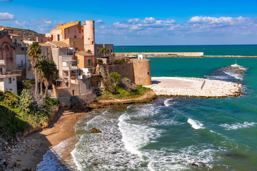 Sunny Cala Petrolo Beach, Mediterranean sea and medieval fortress in Cala Marina, harbor in coastal city Castellammare del Golfo, Sicily, Italy