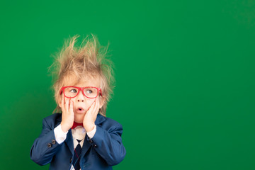 Bright idea! Surprised child student against green chalkboard
