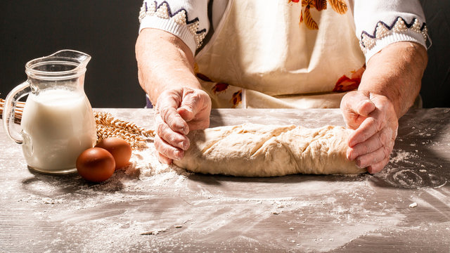 Photo of flour and women hands with flour splash. Cooking bread. Kneading the Dough. Isolated on dark background. Empty space for text