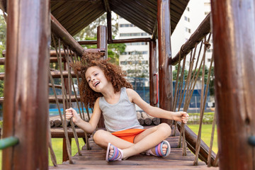 Caucasian girl playing on playground. Child playing alone in a park with social distance.