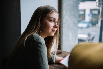 Adult woman looking away against window in building