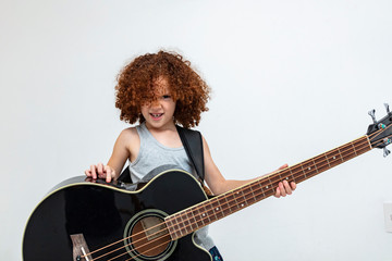 Brazilian and caucasian girl with curly hair, happy child playing guitar, double bass, musical...
