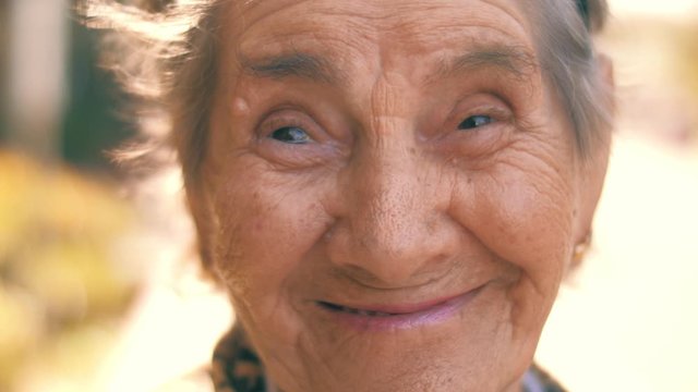 Portrait of happy smiling 92 year old senior woman outdoors. Closeup, 4K UHD, slow motion.