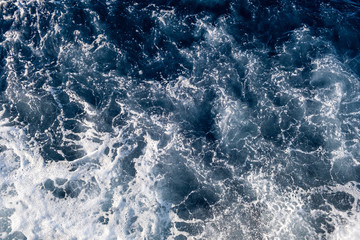 Top down aerial view of sea water surface. White foam waves texture as natural background.