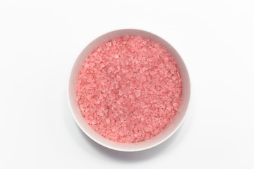 Pink bath salt in bowl on white background . Top view. SPA concept.
