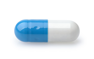 Side view of single blue and white medical capsule