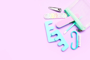 Pedicure travel foot care set on lilac background, top view with copy sace