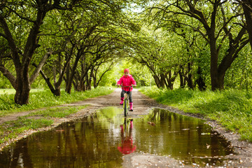 little girl riding bike in water puddle