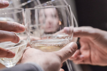 Hands and glasses of toasting friends close up