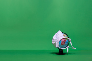 Weltkugel mit weißer Maske mit Blick auf Afrika auf grünem Hintergrund