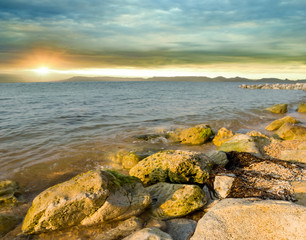 Fototapeta na wymiar stony sea coast at the dramatic sunset