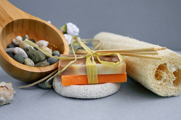 The bath accessories for spa treatments towel,  washcloth,  soap, stones on grey background.  Spa salon concept.