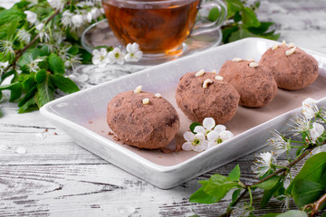 Kartoshka cake on the ceramic platter on the white wooden table. Russian potato-shaped dessert
