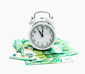 Old alarm clock watch with euro banknotes money, isolated on white background. Time and business concept.