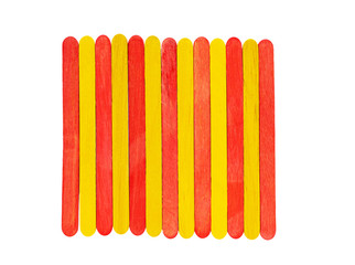 red and yellow wooden ice cream sticks on a white plain background.